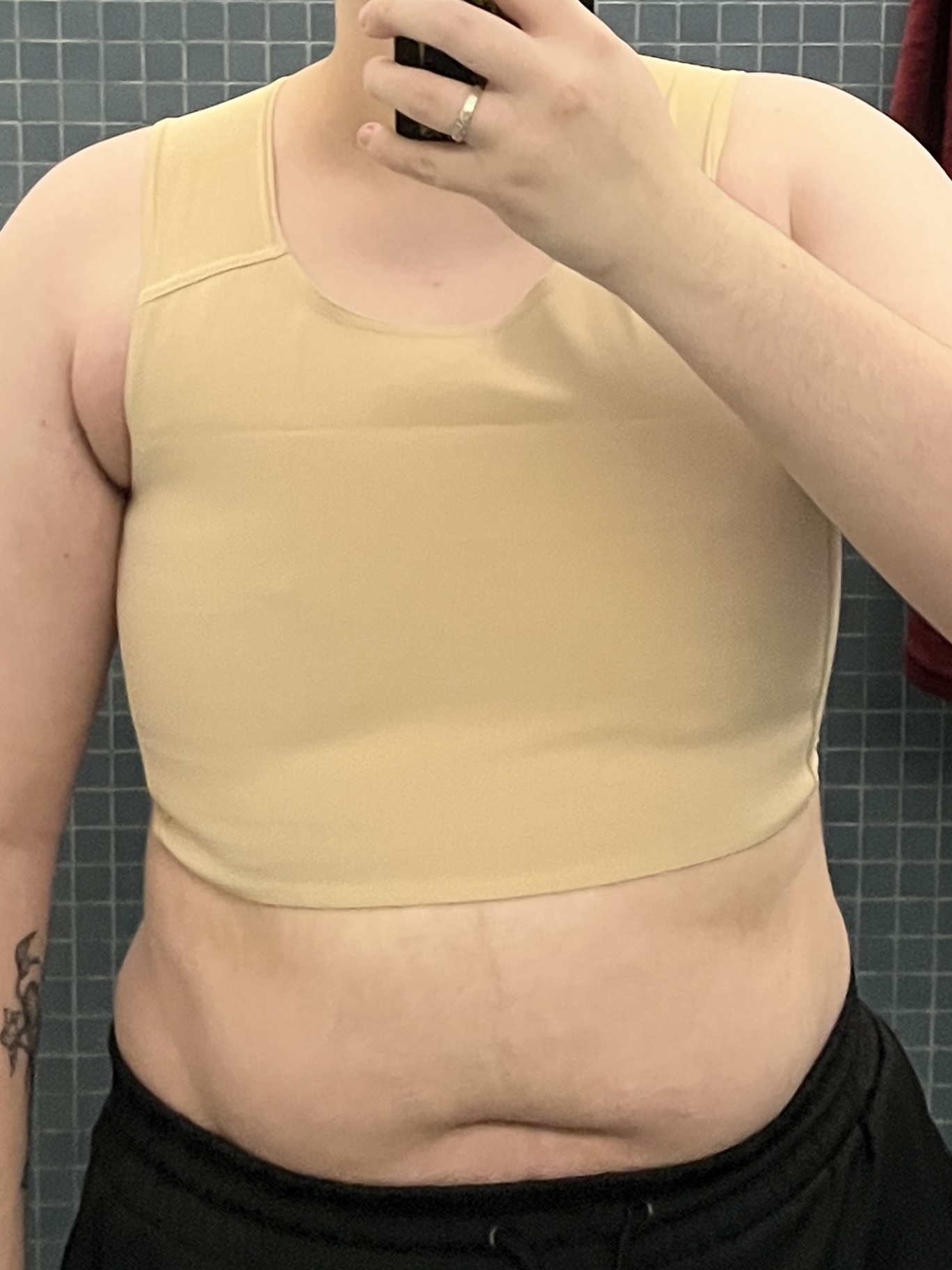 Trans man wearing a tan half binder